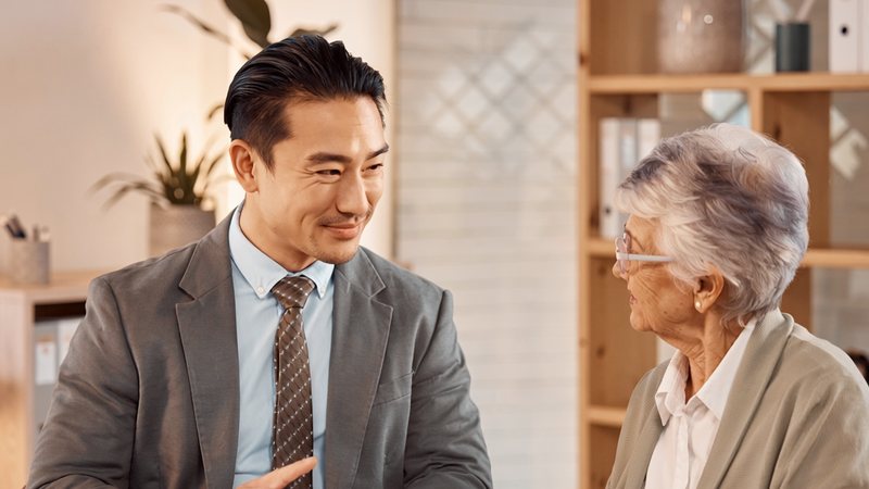 保険書類をご年配のお客様に説明するスタッフ